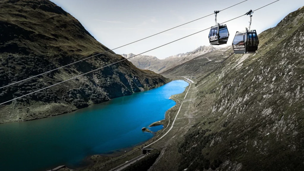 Cable cars over a blue lake in the Swiss Alps with a private chauffeur experience