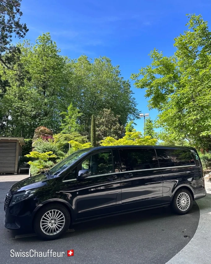 Private chauffeur van in Switzerland by SwissChauffeur parked under green trees on a sunny driveway
