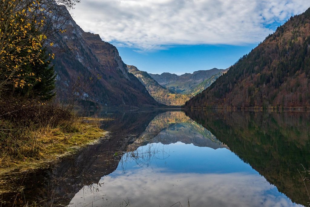 Autumn reflections on a Swiss alpine lake during a chauffeur-driven trip in Switzerland